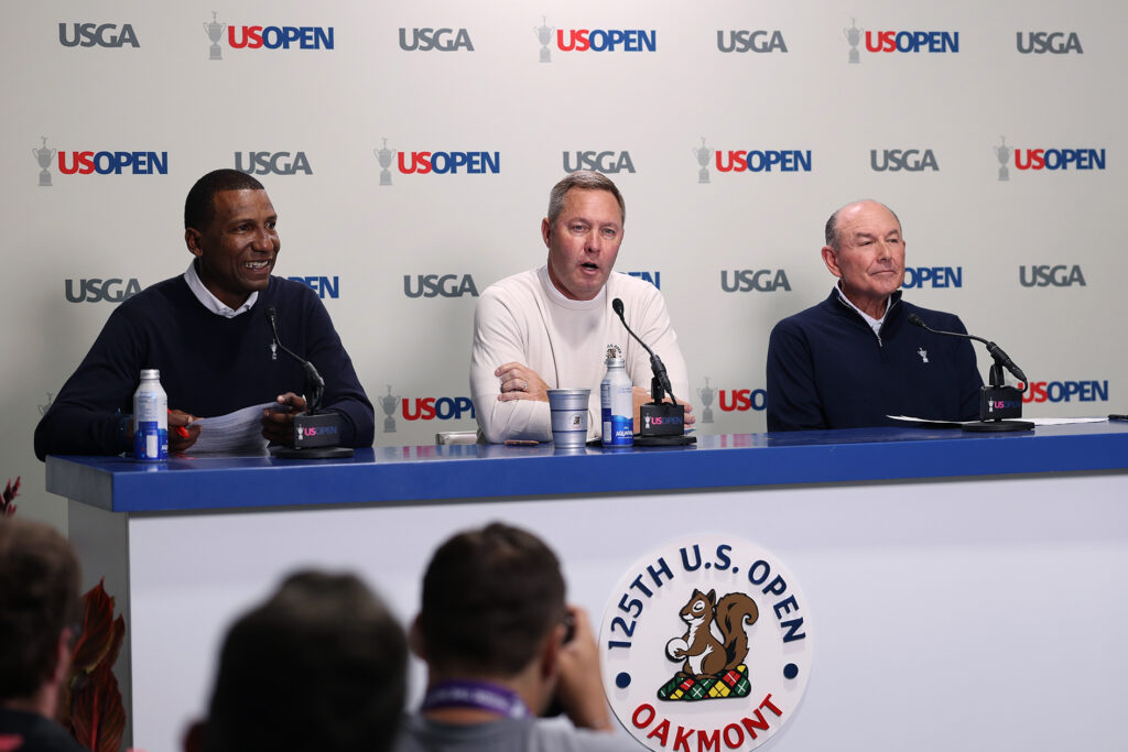 USGA-personer sitter vid ett skrivbord och pratar om golf