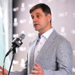 brian rolapp i grå kavaj bakom en mikrofon