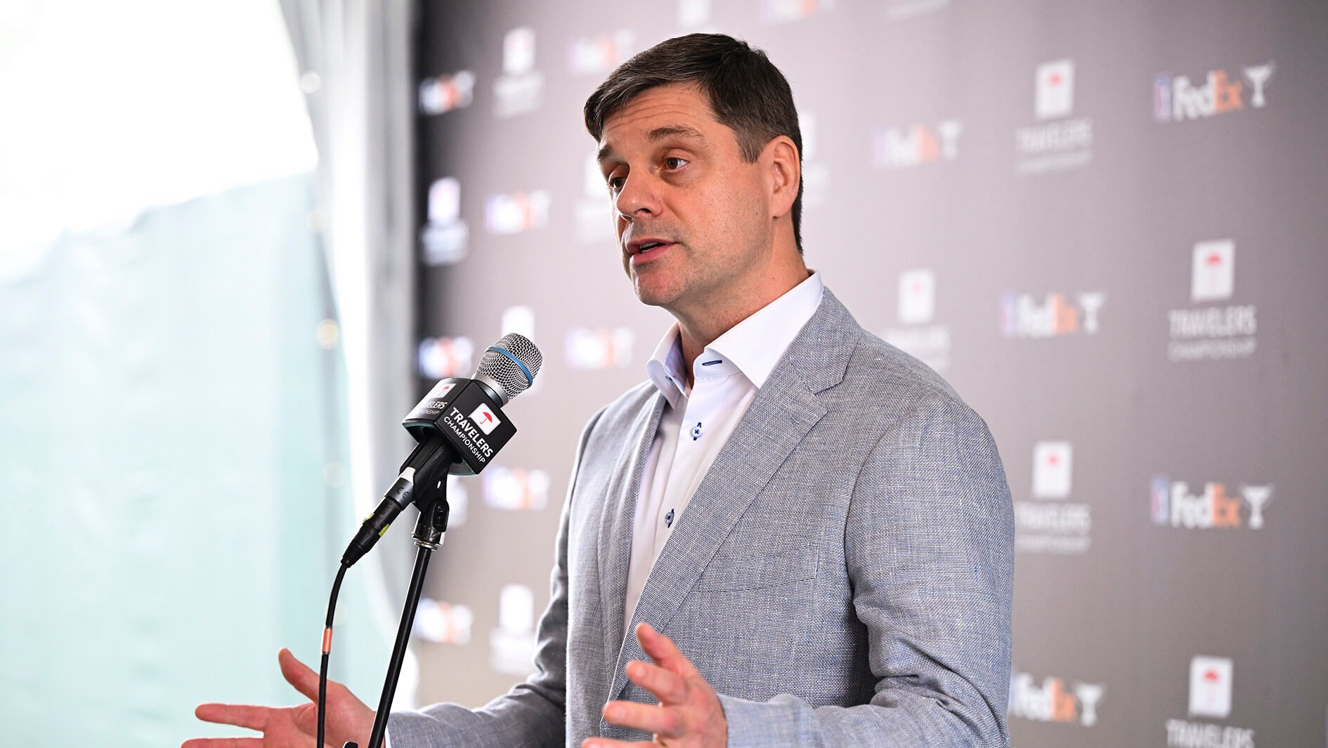 brian rolapp i grå kavaj bakom en mikrofon