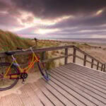 orange cykel på strand i nederländerna