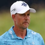 golfspelaren henrik stenson i vit golfkeps och blå, mönstrad golfpiké