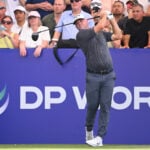 golfspelaren alex norén framför en blå skylt på en golfbana