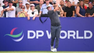 golfspelaren alex norén framför en blå skylt på en golfbana