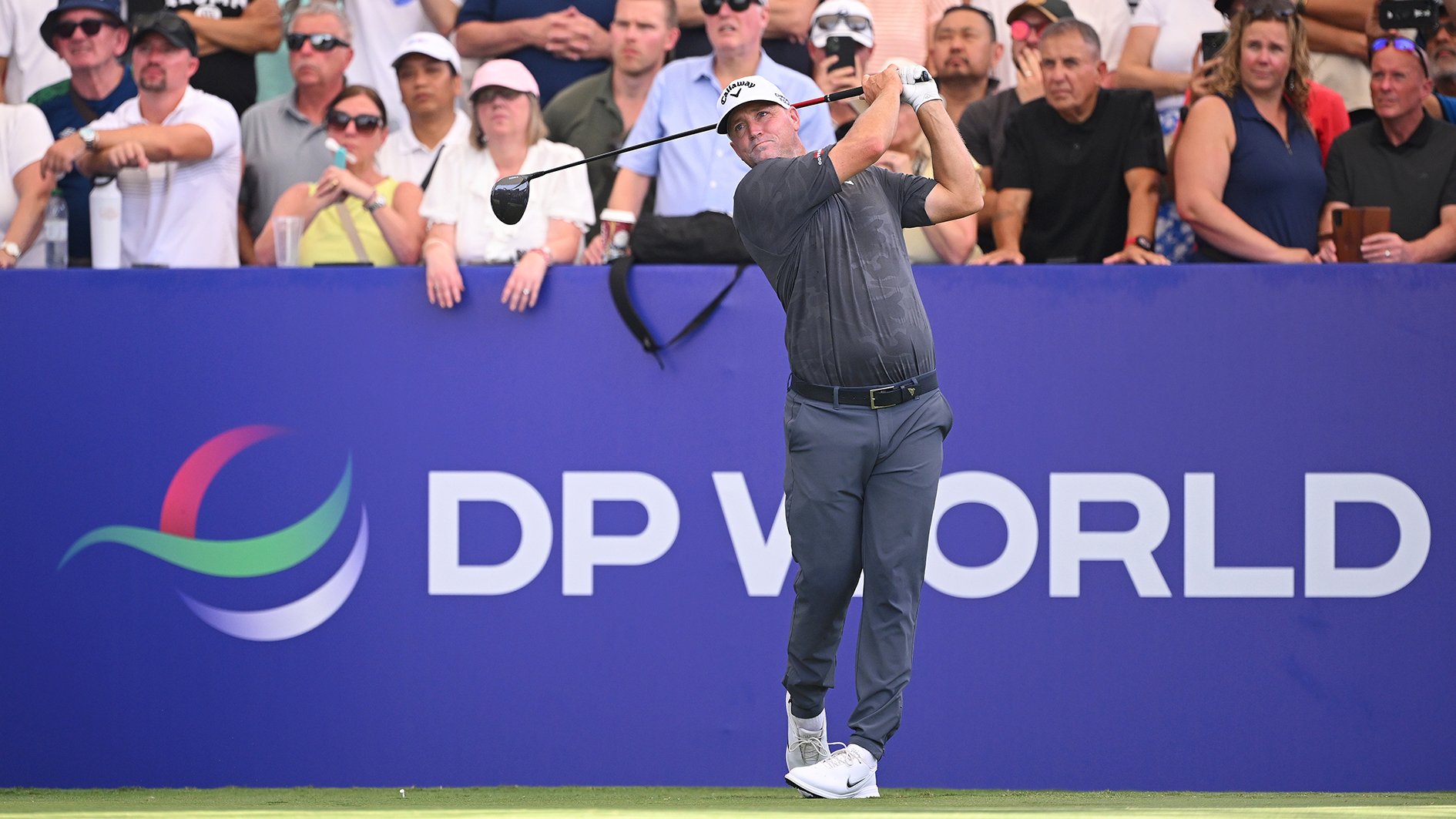 golfspelaren alex norén framför en blå skylt på en golfbana