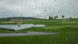 regndroppar på ruta ut mot golfbana