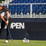 golfspelaren tiger woods slår med en järnklubba från tee på en golfbana