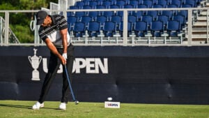 golfspelaren tiger woods slår med en järnklubba från tee på en golfbana