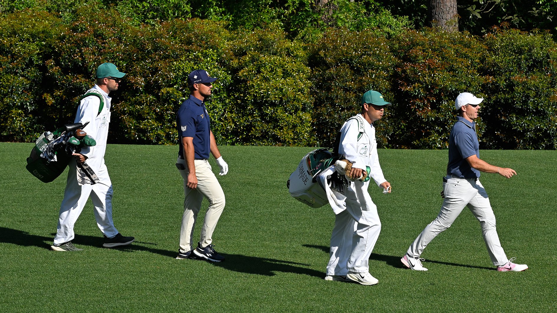 golfspelarna bryson dechambeau och rory mcilroy på en grön golfbana