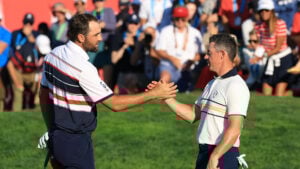 golfspelarna scottie scheffler och rory mcilroy skakar hand på en golfbana