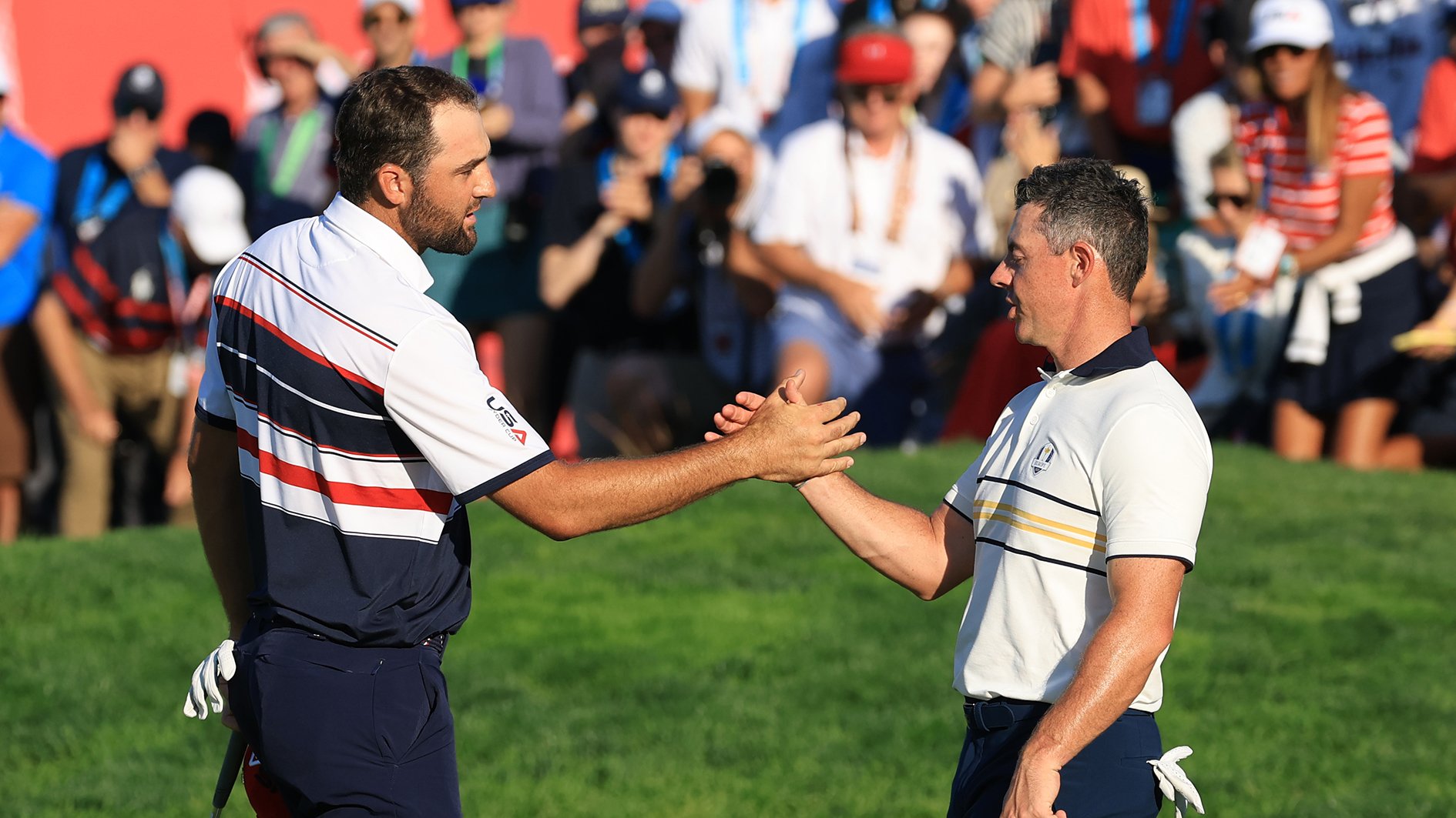 golfspelarna scottie scheffler och rory mcilroy skakar hand på en golfbana