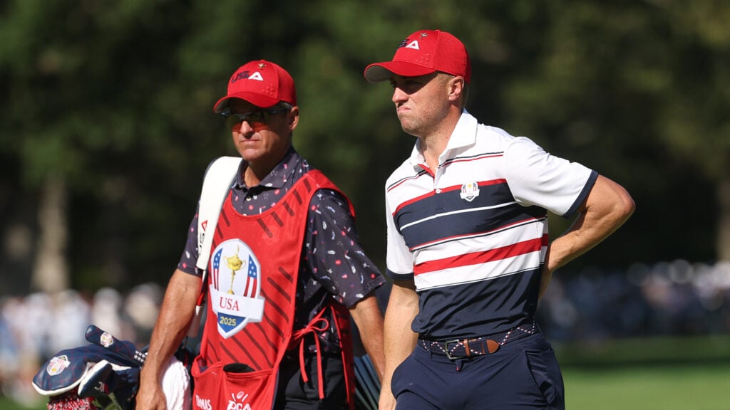golfspelaren justin thomas med caddie på golfbana