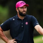 golfspelaren jon rahm i rosa golfkeps och svart golfpiké