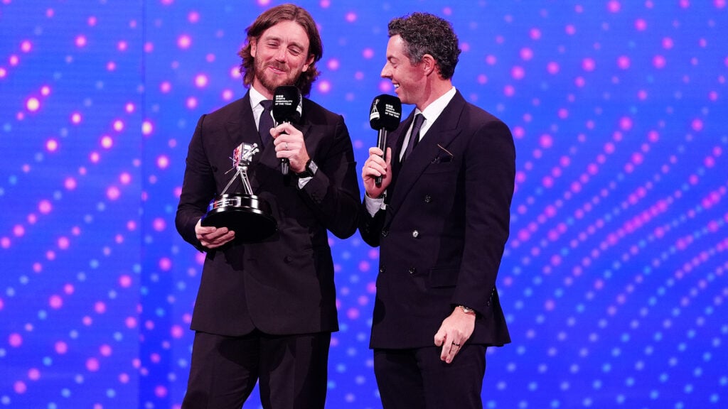 golfspelarna tommy fleetwood och rory mcilroy iklädda svarta kostymer.