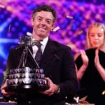 golfspelaren rory mcilroy tar emot pris iklädd svart kostym