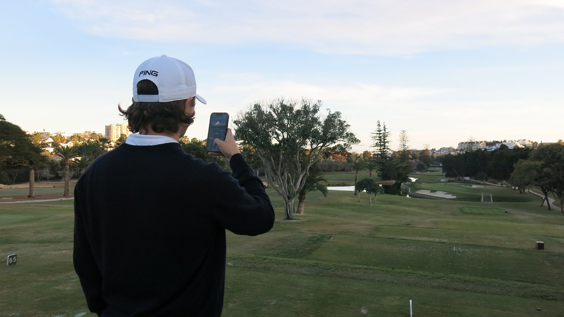 golfspelare med mobil på en golfbana