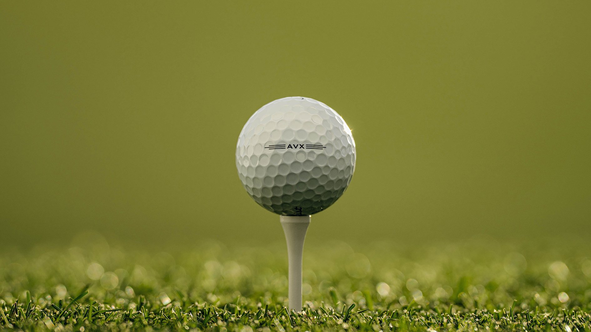 vit golfboll på vit golfpeg i grönt gräs