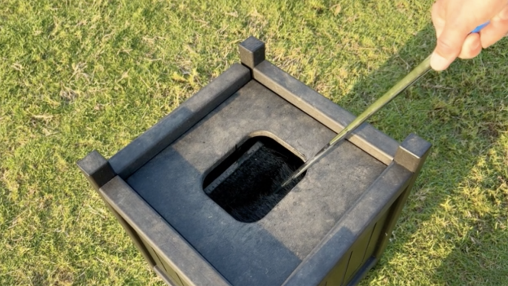 klubbtvätt på golfbana stående i kortklippt gräs