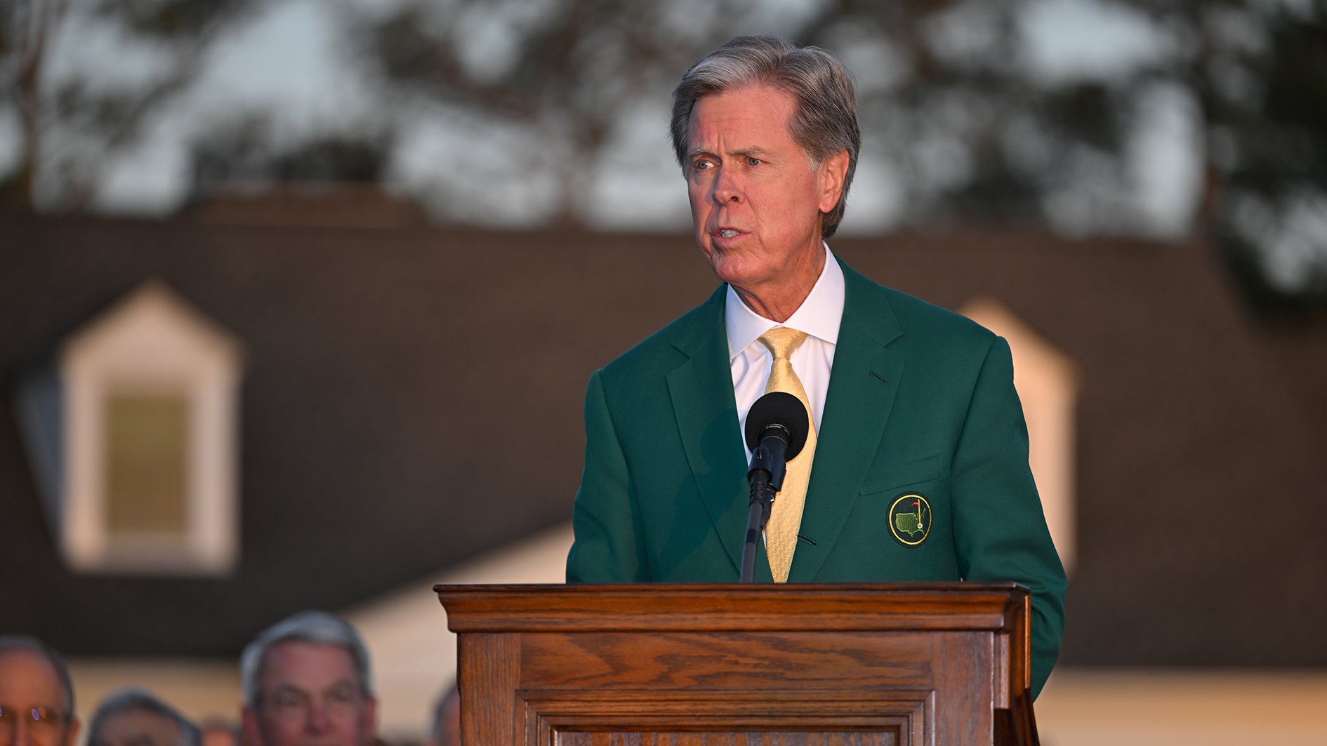 augusta national golf clubs och the masters ordförande Fred Ridley vid ett podium i trä iklädd grön kavaj