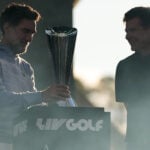 två män vid ett podium och en pokal