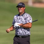 golfspelaren patrick reed i svartvit-mönstrad golfpiké på en golfbana