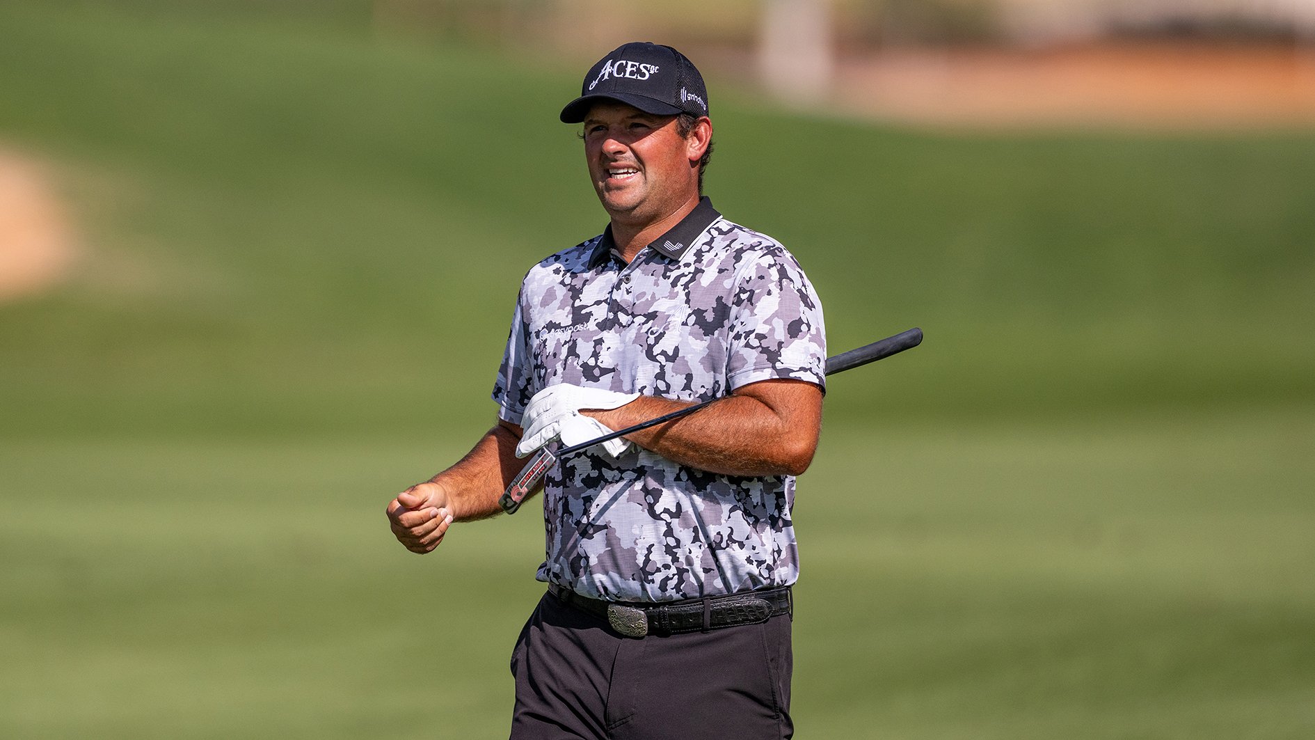 golfspelaren patrick reed i svartvit-mönstrad golfpiké på en golfbana