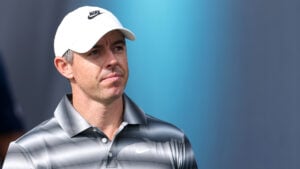 golfspelaren rory mcilroy med vit golfkeps och randig golfpiké