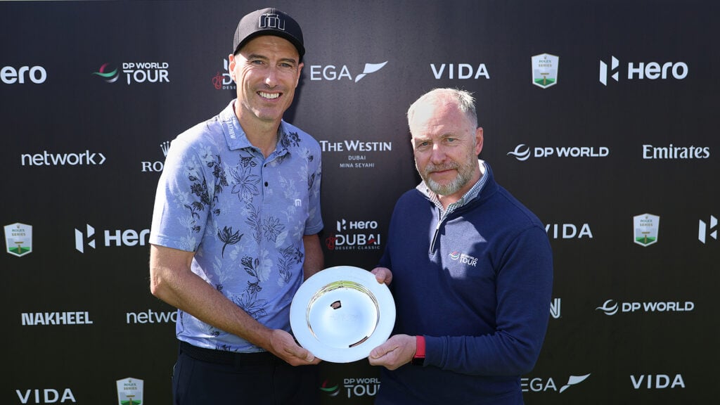 två män i golfkläder håller i ett pris