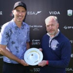 två män i golfkläder håller i ett pris