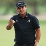 golfspelaren patrick reed i svarta golfkläder på grön golfbana