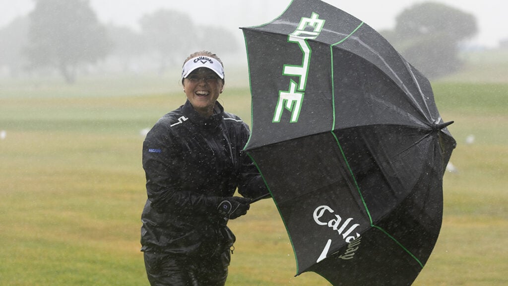 golfspelare i regn med paraply