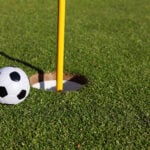 golfhål, fotboll, golfboll, grönt gräs, gul flaggstång