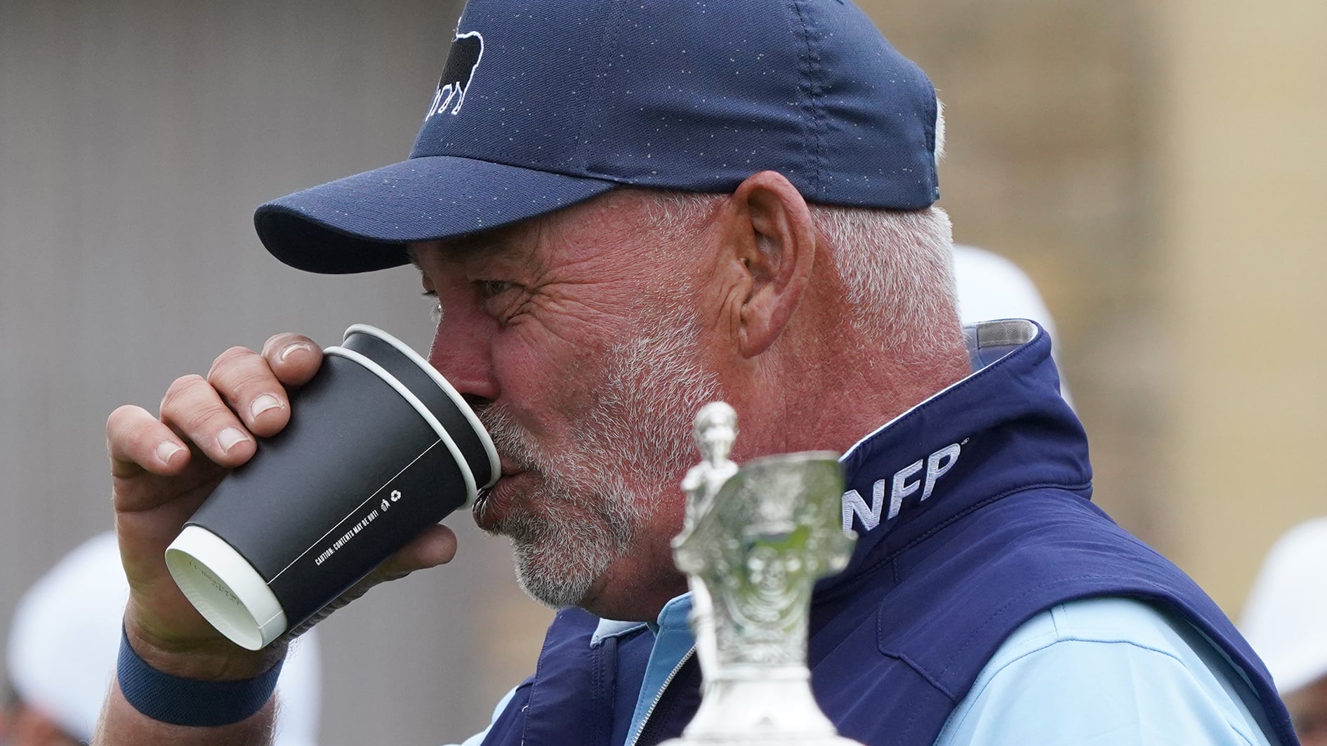 golfspelare dricker kaffe i pappmugg