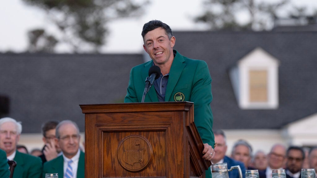 golfspelaren rory mcilroy i grön kavaj vid ett podium