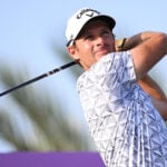 golfspelare i vit golfkeps och med driver