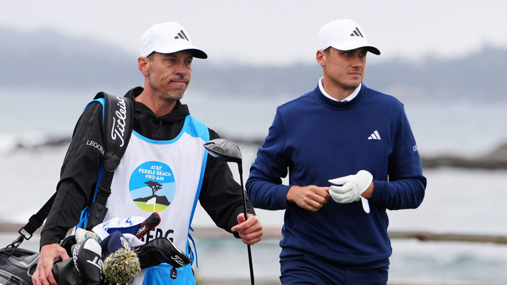 golfspelaren ludvig åberg och caddie på golfbana vid havet