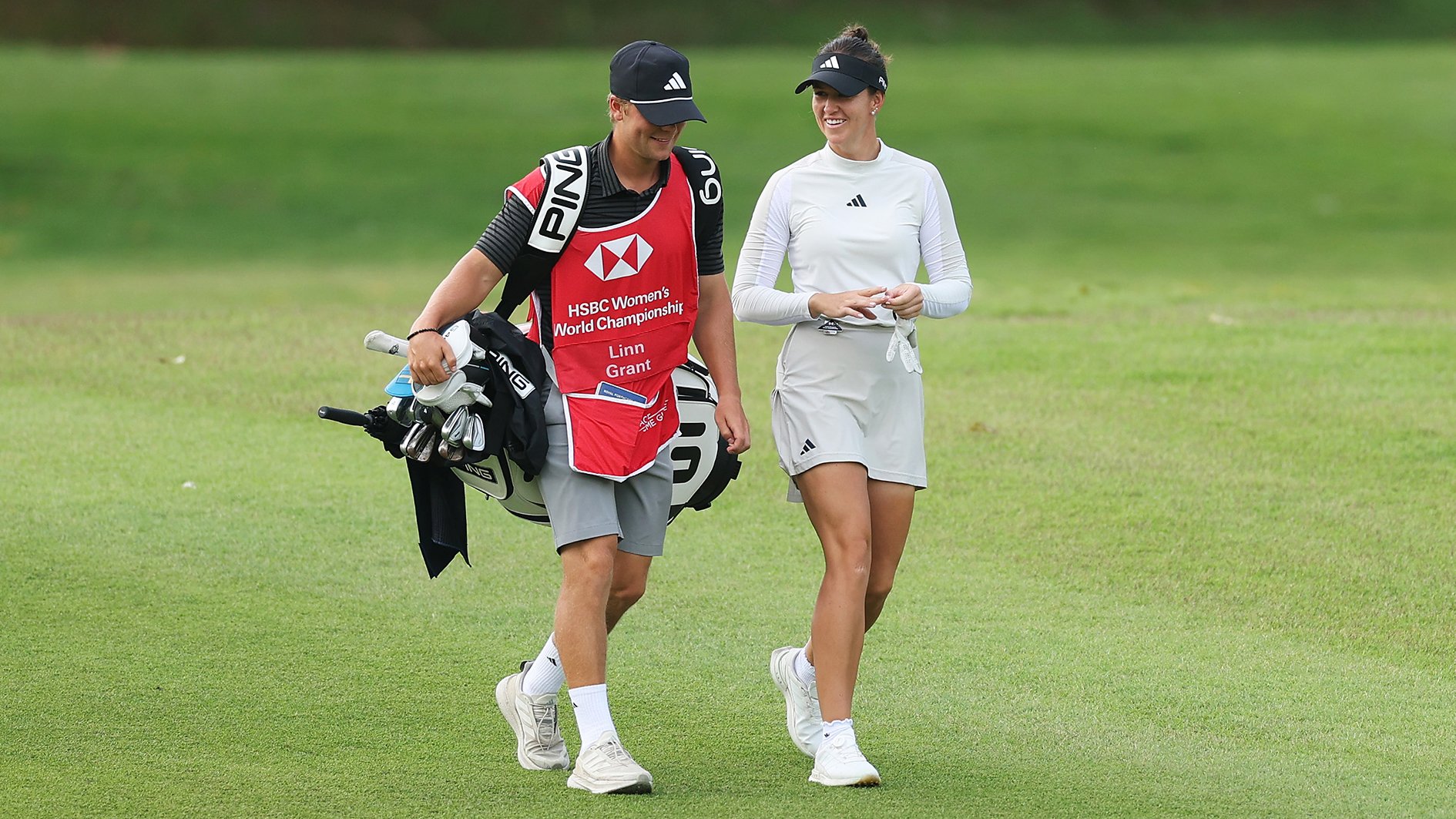 golfspelaren linn grant med caddie på grön golfbana