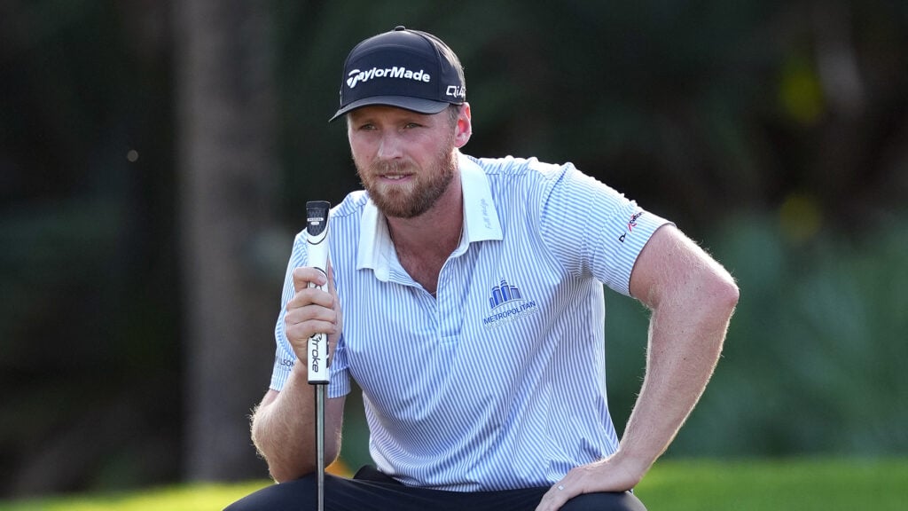 golfspelaren pontus nyholm i vit golfpiké, svart golfkeps och putter