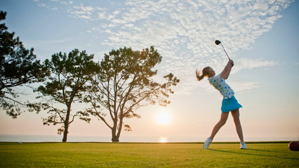 Teen girl making a drive on the golf course