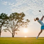 Teen girl making a drive on the golf course