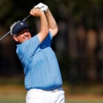 golfspelare slår med golfklubb på en golfbana