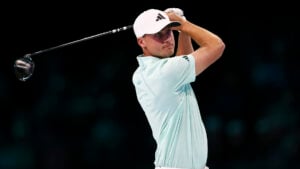 golfspelaren ludvig åberg spelar golf inomhus i ljusa golfkläder
