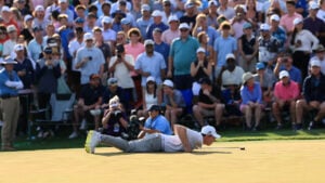 golfspelare, golfgreen, man på mage på gräs, publik, kameror,