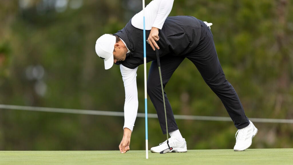 golfspelaren ludvig åberg lagar ett nedslagsmärke på en golfgreen