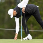 golfspelaren ludvig åberg lagar ett nedslagsmärke på en golfgreen