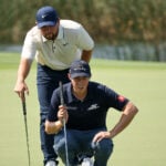 golfspelare läser puttlinje tillsammans