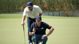 golfspelare läser puttlinje tillsammans