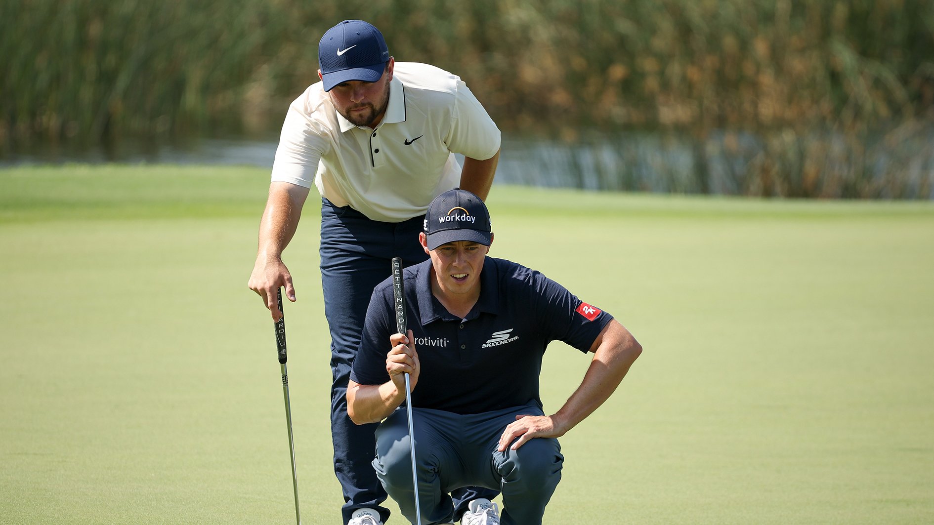 golfspelare läser puttlinje tillsammans