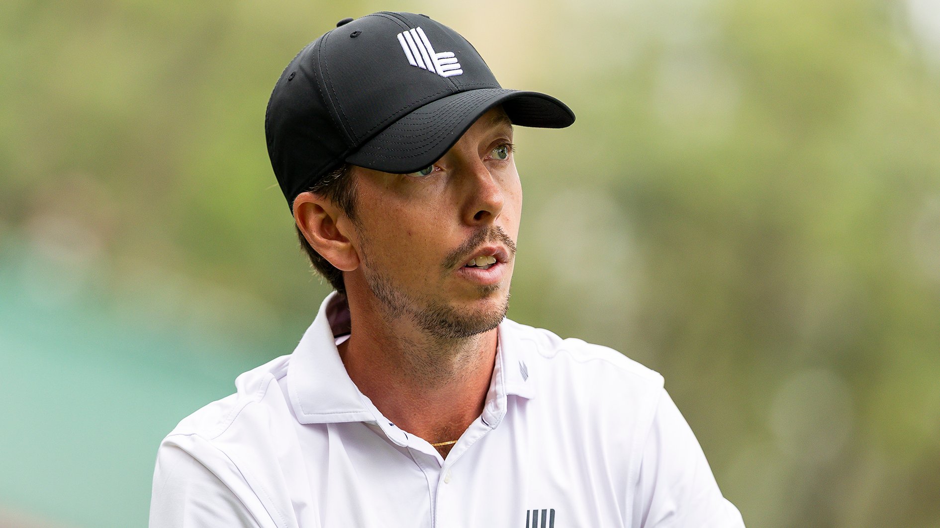 golfspelare med svart golfkeps och vit golfpiké