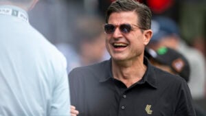 man i golfpiké och solglasögon skrattar