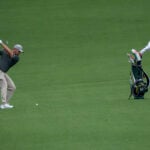 golfspelaren bryson dechambeau på golfbanan augusta national golf club med sin caddie iklädd vit overall
